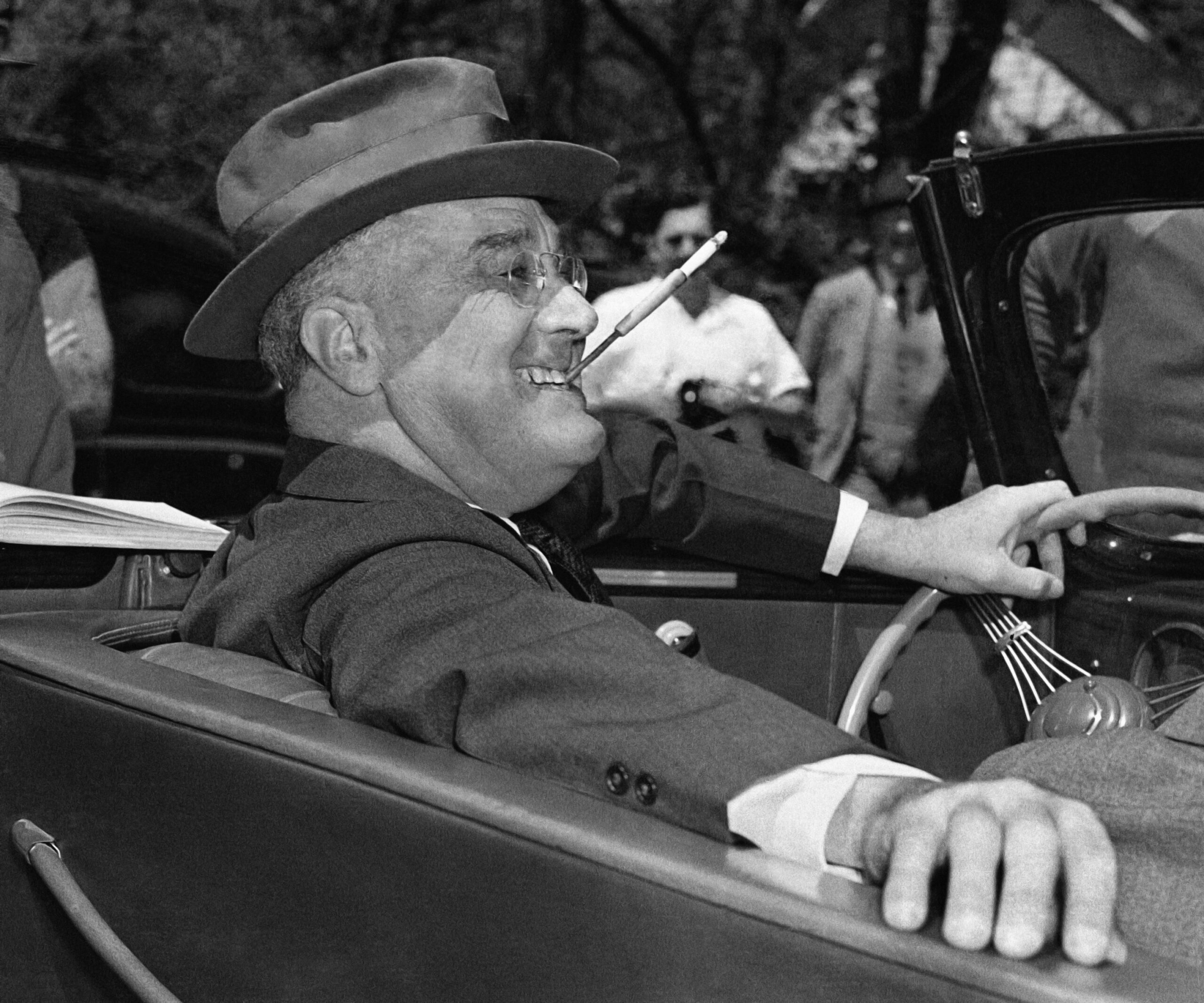President Franklin D. Roosevelt sits at the wheel of his car in Warm Springs, Georgia, April 1939, fielding questions at an outdoor news conference. (AP Photo)