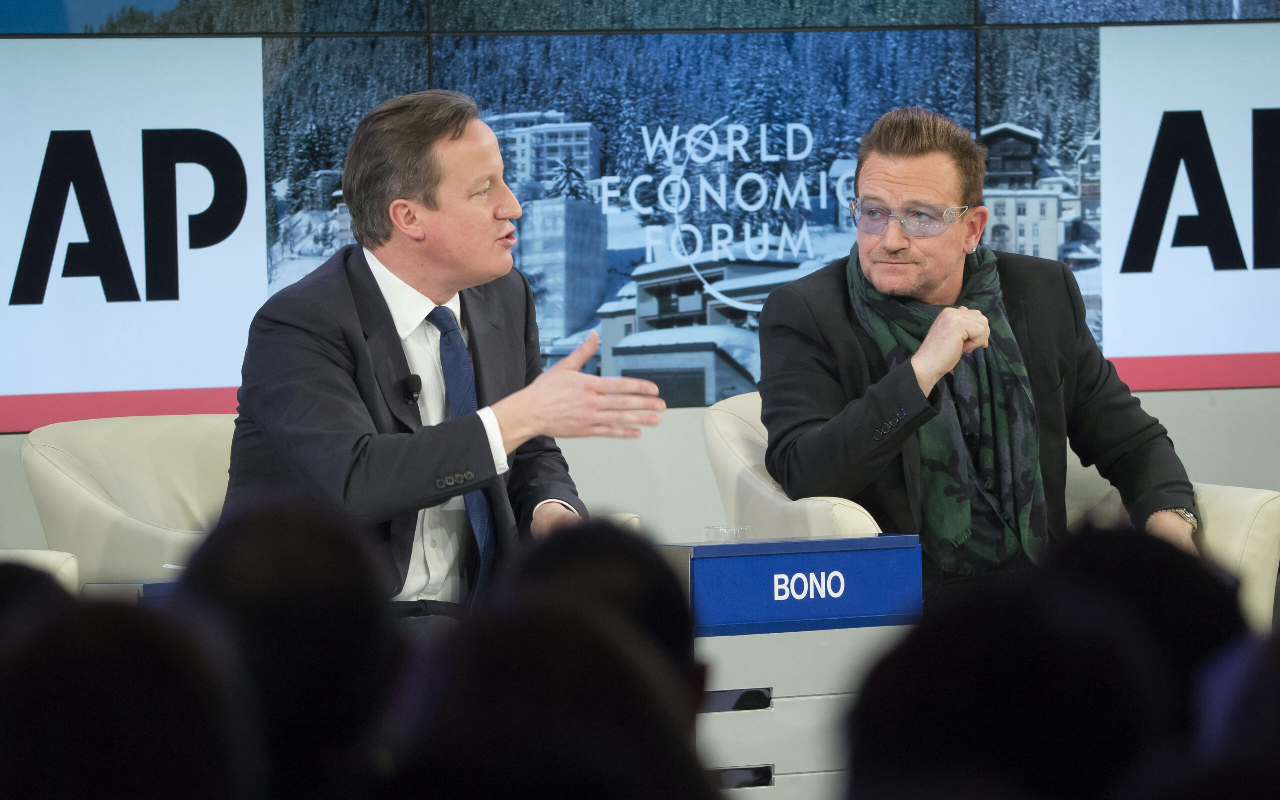 British Prime Minister David Cameron and rock star Bono speak during the panel discussion "The Post-2015 Goals: Inspiring a New Generation to Act," the fifth annual Associated Press debate, at the World Economic Forum in Davos, Switzerland, Friday, Jan. 24, 2014. (AP Photo/Michel Euler)