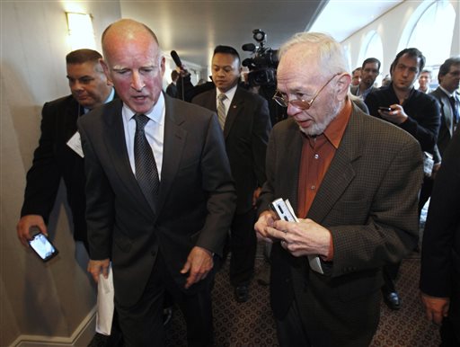 In this Wednesday, Jan. 19, 2011 photo former Associated Press Correspondent Doug Willis, right, talks with Gov. Jerry Brown in Sacramento, Calif. Willis, who covered California politics for the AP for more than three decades, passed away Tuesday, Dec. 15, 2015, from complications following hip surgery. He was 77. (AP Photo/Rich Pedroncelli)