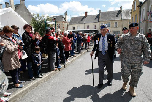 U.S. WW II veteran 89 year old Arden C. Earll, from Erie Pensylvania, who landed on Omaha Beach on June 6, 1944 with the 29th infantry division regiment, is applauded as he arrives at a ceremony in honor of the division, in La Cambe, France, as part of the commemoration of the 70th D-Day anniversary, Wednesday June 4, 2014. World leaders and veterans are preparing to mark the 70th anniversary of the invasion this week in Normandy. (AP Photo/Claude Paris)