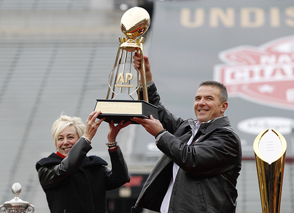 Ohio State coach Urban Meyer, right, and Eva Parziale, east regional director for The Associated Press, hold up the AP college football championship trophy as the Buckeyes were the unanimous No. 1 selection in the final AP Top 25 of the 2014 season. The trophy was presented at a national championship celebration at Ohio Stadium in Columbus, Ohio, Saturday, Jan. 24, 2015. (AP Photo/Paul Vernon)