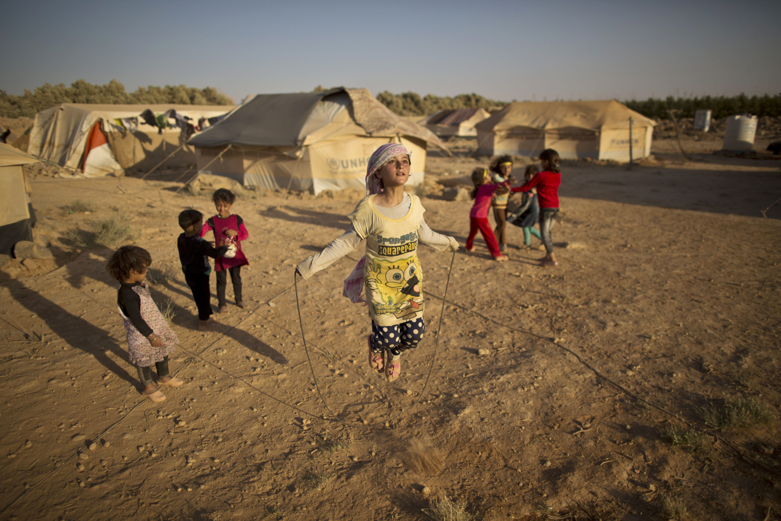 A Syrian girl skips a rope while she and other children play near their tents at an informal tented settlement near the Syrian border on the outskirts of Mafraq, Jordan, July 19, 2015. This is one of the images that will be on display at Xposure International Photography Festival. (AP Photo/Muhammed Muheisen)