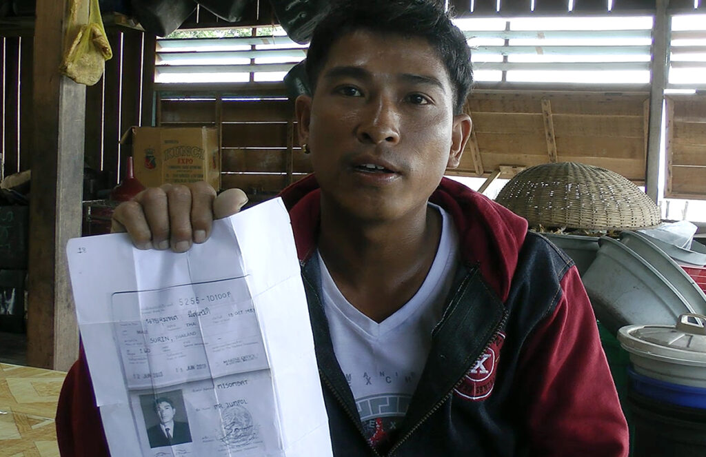 Maung Soe of Myanmar holds up a copy of the seafarer’s book given to him before he boarded a Thai fishing trawler, in Benjina, Indonesia, Nov. 27, 2014.