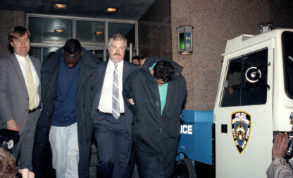 In this April 22, 1989 file photo, Yusef Salaam, 15, second from left, and Raymond Santana, 14, right, are led from the 24th Precinct by a detective after their arrest in connection with the rape and severe beating of a woman jogging in Central Park. (AP Photo/David Burns, File)