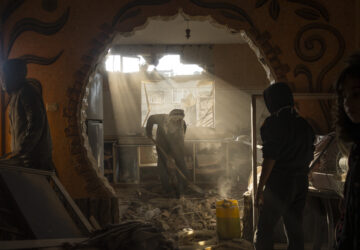 FILE - Palestinians look at their neighbor's damaged house following an Israeli strike in Rafah, southern Gaza Strip, Saturday, Jan. 27, 2024. (AP Photo/Fatima Shbair, File)
