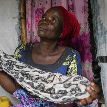 Nelly Shukuru, 51, hold the scarf she had planned on using to hang herself after spending three years displaced in the Lushagala camp in Goma, Democratic Republic of the Congo, Tuesday, Aug. 27, 2024. (AP Photo/Moses Sawasawa)