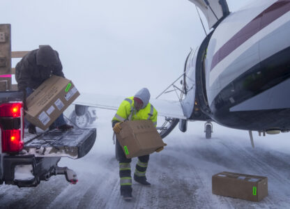 In blizzard winds, Lee Kayotuk, center, helps unload cargo from the one flight of the day in and out of the village in Kaktovik, Alaska, Thursday, Oct. 17, 2024. (AP Photo/Lindsey Wasson)
