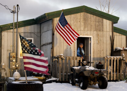 Alice Aishanna poses for a portrait outside her home displaying several American flags in Kaktovik, Alaska, Tuesday, Oct. 15, 2024. (AP Photo/Lindsey Wasson)