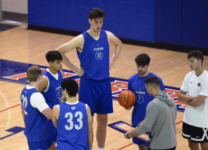 Olivier Rioux, back center, a 7-foot-9 NCAA college basketball player at Florida, gathers with coaches and teammates at the team's practice, Friday, Oct. 18, 2024, in Gainesville, Fla. (AP Photo/John Raoux)