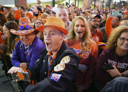 FILE - Clemson fans cheer on the Tigers as they arrive at Williams-Brice Stadium before an NCAA college football game against South Carolina Saturday, Nov. 27, 2021, in Columbia, S.C. (AP Photo/Sean Rayford, File)