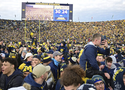 FILE - Fans rush the field after Michigan defeated Ohio State 30-24 in an NCAA college football game, Saturday, Nov. 25, 2023, in Ann Arbor, Mich. (AP Photo/David Dermer)