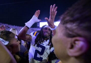 FILE - LSU safety Jardin Gilbert (2) celebrates with fans after they rushed the field after the team's overtime victory against Mississippi in an NCAA college football game in Baton Rouge, La., Saturday, Oct. 12, 2024. (AP Photo/Matthew Hinton, File)