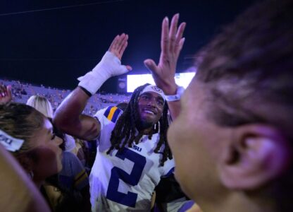 FILE - LSU safety Jardin Gilbert (2) celebrates with fans after they rushed the field after the team's overtime victory against Mississippi in an NCAA college football game in Baton Rouge, La., Saturday, Oct. 12, 2024. (AP Photo/Matthew Hinton, File)
