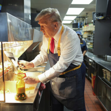 Republican presidential nominee former President Donald Trump serves french fries as an employee looks on during a visit to McDonald's in Feasterville-Trevose, Pa., Sunday, Oct. 20, 2024. (Doug Mills/The New York Times via AP, Pool)