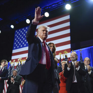 Republican presidential nominee former President Donald Trump waves as he walks with former first lady Melania Trump at an election night watch party at the Palm Beach Convention Center, Wednesday, Nov. 6, 2024, in West Palm Beach, Fla. (AP Photo/Evan Vucci)