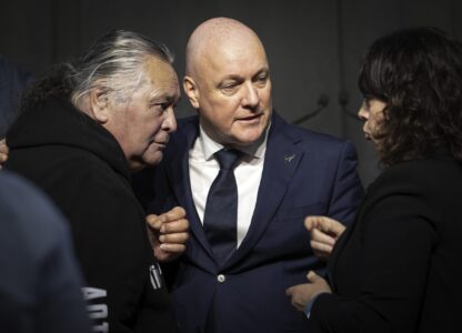 New Zealand's Prime Minister Christopher Luxon, center, talks with survivor Whiti Ronaki, left, and Laura Cherrington following his 