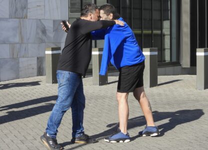 Two men great each other with a hongi, a Maori greeting, as they arrive at Parliament House in Wellington, New Zealand, ahead of the apology to the survivors of abuse in state, faith-based and foster care over a period of seven decades, Tuesday, Nov. 12, 2024. (AP Photo/Charlotte Graham-McLay )