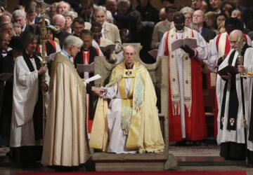FILE - The Most Reverend Justin Welby sits in the Chair of St Augistine as the Dean of Canterbury Robert Willis takes him by the hand during his enthronement service to become Archbishop of Canterbury at Canterbury Cathedral in Canterbury, England, Thursday, March 21, 2013. (Gareth Fuller, Pool Photo via AP, File)