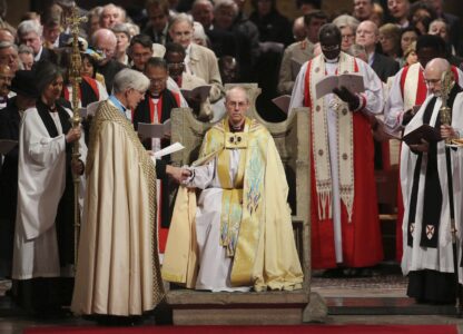 FILE - The Most Reverend Justin Welby sits in the Chair of St Augistine as the Dean of Canterbury Robert Willis takes him by the hand during his enthronement service to become Archbishop of Canterbury at Canterbury Cathedral in Canterbury, England, Thursday, March 21, 2013. (Gareth Fuller, Pool Photo via AP, File)