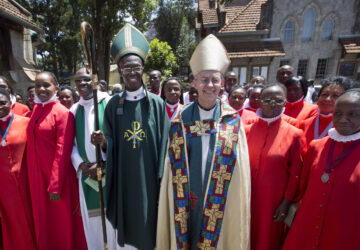 FILE - The Archbishop of Canterbury Justin Welby, center-right, accompanied by Archbishop of Kenya Eliud Wabukala, center-left, poses for a photograph with members of the choir after conducting a service at the All Saints Cathedral in Nairobi, Kenya, Sunday, Oct. 20, 2013. (AP Photo/Ben Curtis, File)
