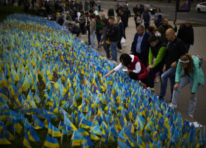 People place Ukrainian flags in memory of civilians killed during the war at Independence Square in central Kyiv, Ukraine, Saturday, Oct. 1, 2022. (AP Photo/Francisco Seco)