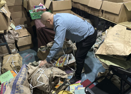 Secondhand bookstore owner Wang Yingxing bundles books at a storage shed near his shuttered shop in Ningbo, in eastern China's Zhejiang province, Oct. 9, 2024. (AP Photo/Dake Kang)