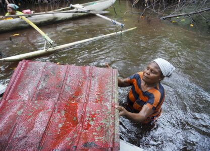 Paula Hamadi cleans up trash as she collects clams in a mangrove forest where only women are permitted to enter in Jayapura, Papua province, Indonesia on Wednesday, Oct. 2, 2024. (AP Photo/Firdia Lisnawati)