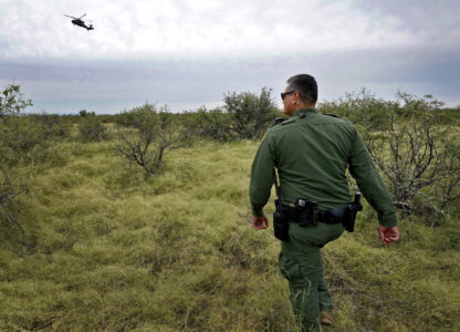 U.S. Border Patrol agent Jesus Vasavilbaso, aided by a Black Hawk helicopter, searches for a group of migrants evading capture in the desert brush at the base of the Baboquivari Mountains, Thursday, Sept. 8, 2022, near Sasabe, Ariz. (AP Photo/Matt York, File)