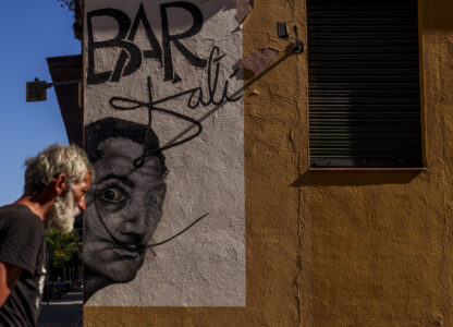 FILE - A man walks past a drawing representing the Spanish surrealist artist Salvador Dali during a hot and sunny day in Madrid, Spain, Thursday, July 13, 2023. (AP Photo/Manu Fernandez, File)