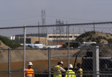 Workers talk outside an Amazon Web Services data center that is under construction on Wednesday, Aug. 21, 2024, in Boardman, Ore. (AP Photo/Jenny Kane)