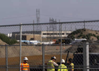 Workers talk outside an Amazon Web Services data center that is under construction on Wednesday, Aug. 21, 2024, in Boardman, Ore. (AP Photo/Jenny Kane)