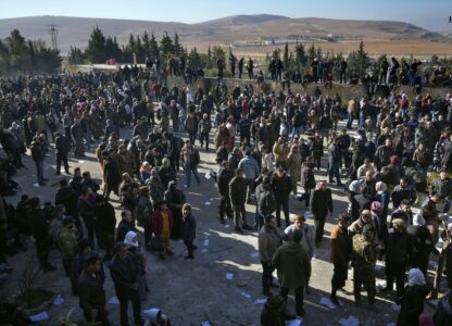 People stand outside the infamous Saydnaya military prison, just north of Damascus, Syria, Monday, Dec. 9, 2024. Crowds are gathering to enter the prison, known as the 