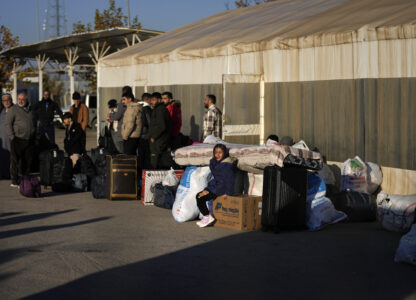 Syrians wait to cross into Syria from Turkey at the Oncupinar border gate, near the town of Kilis, southern Turkey, Monday, Dec. 9, 2024. (AP Photo/Khalil Hamra)