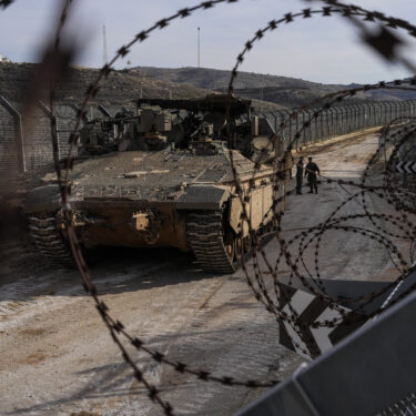 Israeli soldiers stand next to armored vehicles parked near the so-called Alpha Line that separates the Israeli-annexed Golan Heights from Syria, in the town of Majdal Shams, Monday, Dec. 9, 2024. (AP Photo/Matias Delacroix)