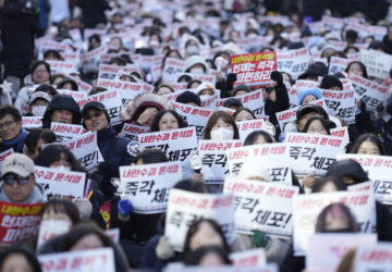 Participants shout slogans during a rally calling on the Constitutional Court to dismiss the President Yoon Suk Yeol in Seoul, South Korea, Sunday, Dec. 15, 2024. The signs read 