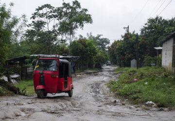 A three-wheeled motorized taxi drives along a dirt road on the outskirts of San Pedro Sula, Honduras, Monday, Dec. 9, 2024. (AP Photo/Moises Castillo)