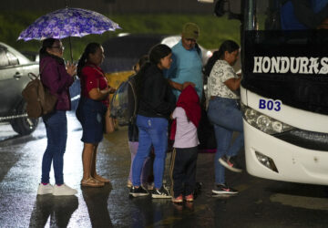 People, mostly Honduran migrants, get on a bus in the hope of reaching the U.S., in San Pedro Sula, Honduras, Tuesday, Dec. 3, 2024. (AP Photo/Moises Castillo)