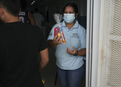 A worker offers personal care kits to Honduran migrants who were deported from the U.S. after they landed at Ramon Villeda Morales Airport in San Pedro Sula, Honduras, Wednesday, Dec. 4, 2024. (AP Photo/Moises Castillo)