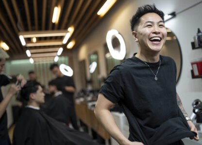 Barbers work on their clients at 12 Pell, a local barbershop in Manhattan's Chinatown, Thursday, Jan. 25, 2024, in New York. Clients are drawn by 12 Pell's social media, in which the young, predominantly Asian American barbers are making a study of cool, offering consultations on style and cut, what's fashionable and not. (AP Photo/John Minchillo)
