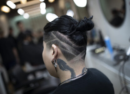 A client is checked for final touchups after a styling at 12 Pell, a local barbershop in Manhattan's Chinatown, Thursday, Jan. 25, 2024, in New York. The clients at the personal care and grooming store aren't just coming from the neighborhood. They're coming from around the metro region and even further, making appointments a month out. (AP Photo/John Minchillo)