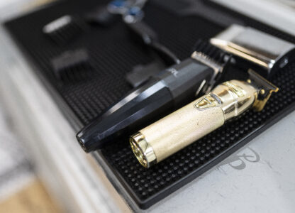 A gold-plated buzzer rests on workstations as barbers tend to their clients at 12 Pell, a local barbershop in Manhattan's Chinatown, Thursday, Jan. 25, 2024, in New York. (AP Photo/John Minchillo)