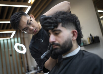 Barbers work on their clients at 12 Pell, a local barbershop in Manhattan's Chinatown, Thursday, Jan. 25, 2024, in New York. (AP Photo/John Minchillo)