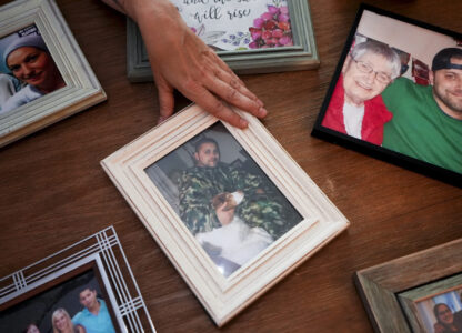 Jen Dold, whose brother, Alex Dold, lived with schizophrenia and died after a 2017 encounter with sheriff's deputies and police officers, displays family photos of her brother Wednesday, Sept. 18, 2024, at her home in Edmonds, Wash. (AP Photo/Lindsey Wasson)