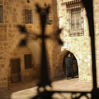 An Armenian Christian priest walks along an alley near to St. James Cathedral at the Armenian quarter in Jerusalem, Thursday, Nov. 21, 2024. (AP Photo/Francisco Seco)