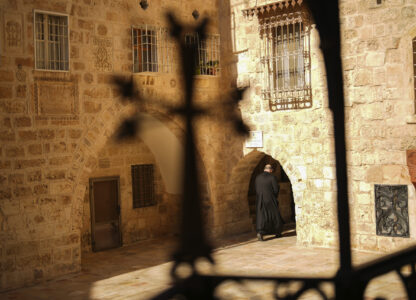 An Armenian Christian priest walks along an alley near to St. James Cathedral at the Armenian quarter in Jerusalem, Thursday, Nov. 21, 2024. (AP Photo/Francisco Seco)