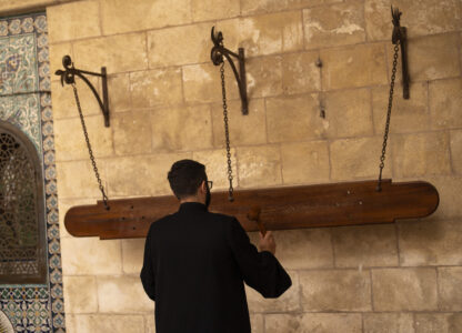 A member of the Armenian clergy uses a wood hammer to call for the daily afternoon prayer service at St. James Cathedral at the Armenian quarter in Jerusalem, Thursday, Nov. 21, 2024. (AP Photo/Francisco Seco)