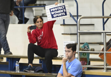 A spectator holds up a Protect Women's Sports sign during the third set of an NCAA college volleyball match between the San Jose State Spartans and the Air Force Falcons Thursday, Oct. 31, 2024, in San Jose, Calif. (AP Photo/Eakin Howard)