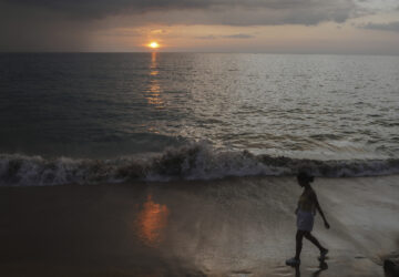A woman walks on Bang Niang Beach, where tsunami hit 2004, Takuapa district of Phang Nga province, southern Thailand, Sunday, Dec. 8, 2024. (AP Photo/Sakchai Lalit)