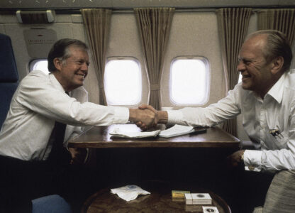 FILE - President Jimmy Carter is seen with former President Gerald Ford aboard Air Force 1 between Cairo and Spain on Oct. 10, 1981. (AP Photo/Dirck Halstead, File)