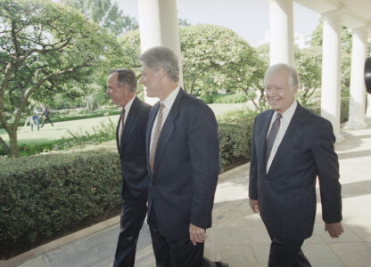 FILE - U.S. President Bill Clinton, flanked by former Presidents George Bush, left, and Jimmy Carter, walks through the Colonnades of the White House, Washington, on Sept. 13, 1993. (AP Photo/Wilfredo Lee, File)